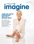 Actress Jamie Lee Curtis, a woman with light skin tone and frosty hair, sits cross-legged as the cover image of Imagine magazine