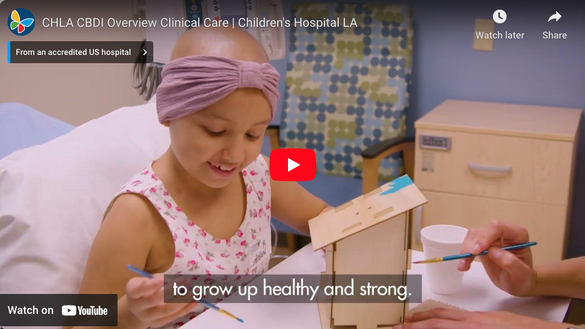 Screengrab of YouTube video player that links to CHLA CBDI Clinical Care video and shows a young cancer patient with medium skin tone and shaved head smiling and painting her in hospital bed