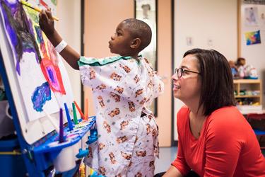 Child Life specialist with a young patient painting