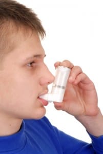 Teen boy using an inhaler