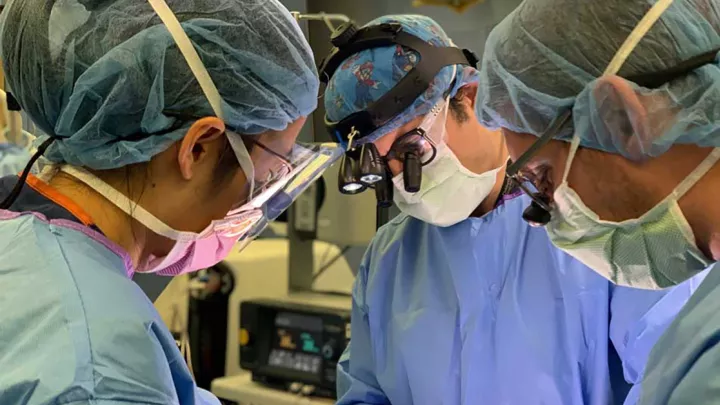 Peter Chiarelli, MD, DPhil and other surgeons at an operating table