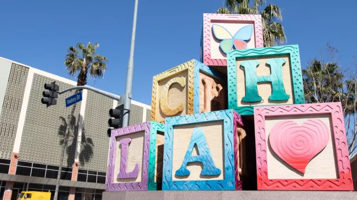 A large, colorful statue of children's toy blocks with the letters C-H-L-A on them, as well as a heart and butterfly logo.