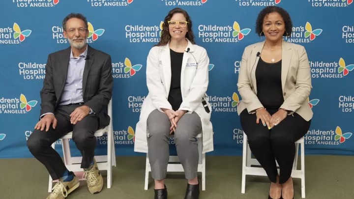 Michael Goran, PhD, Alaina Vidmar, MD, and Senta Georgia, PhD, sit on stage in front of Children's Hospital Los Angeles backdrop