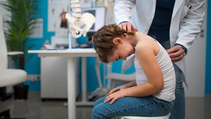 Pediatrician performs development medical exam on young female patient
