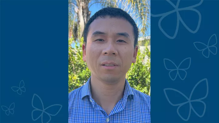 Professional headshot of Xiangming Ding, PhD against blue letterbox background