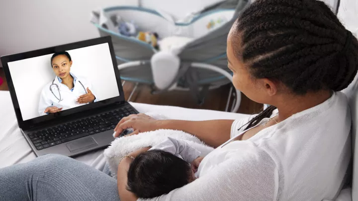 Parent and newborn talk to doctor virtually.