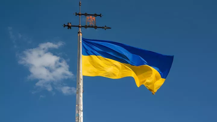 The yellow and blue Ukrainian flag flying in front of a blue sky