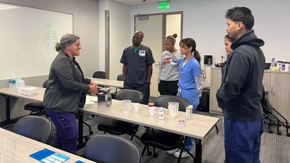 Nursing instructor teaches nursing trainees how to measure liquids