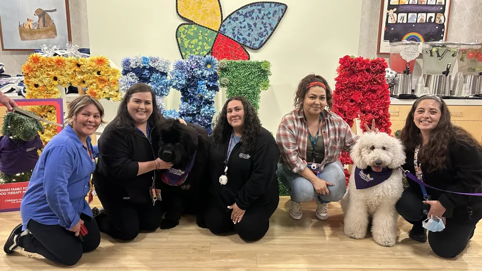 Five CHLA team members pose with therapy dogs at Dog Therapy Appreciation Day