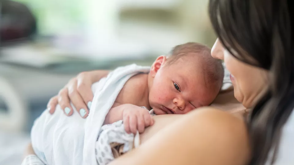 Baby with light skin lies on chest of mother with light skin