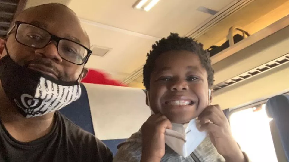 Lawrence and Evan taking a selfie while sitting inside a train