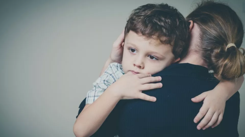Young boy with light skin tone hugs his mother