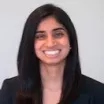 Headshot of woman with light skin tone and dark hair wearing business attire