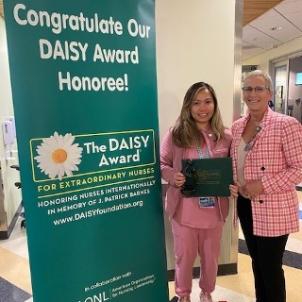 Nina Nacpil, MSN, RN, CCRN, is presented with their DAISY Award