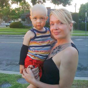 Zia holds 2-year-old Hunter outside their home.