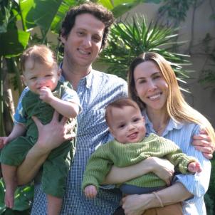 Mother and father with light skin each holding light-skinned infants