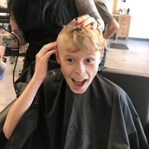 Malakai getting his head shaved at a salon