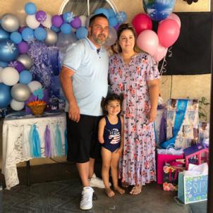 Mila with family with balloons and gifts