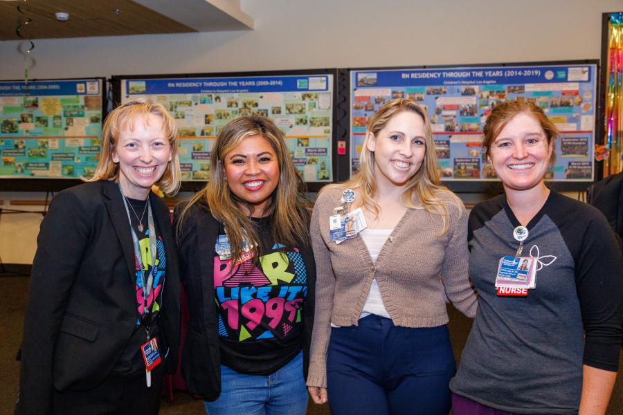 Four nurses smile at the camera.