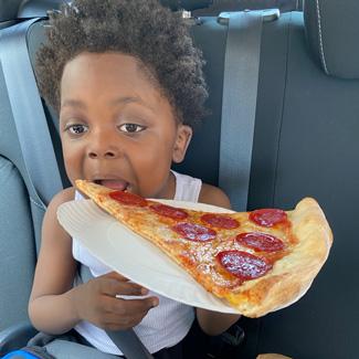Ethan enjoying his first slice of New York pizza