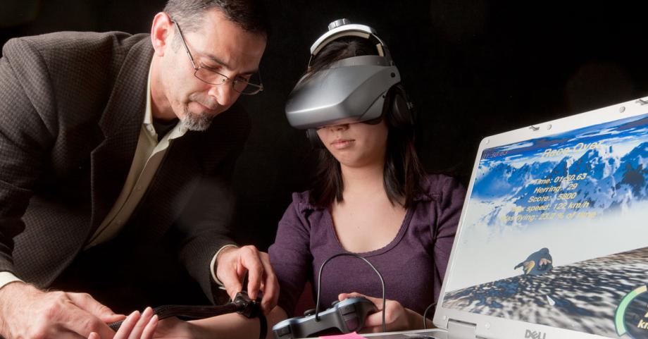 Dr. Gold supervises test subject using virtual reality headset