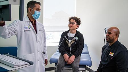 Physician speaking with father and son