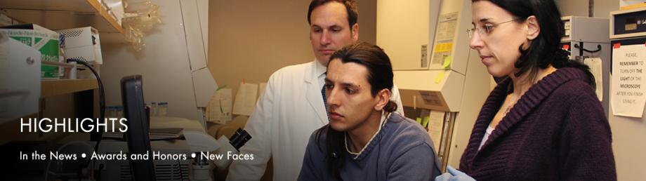 Scientists viewing a computer monitor