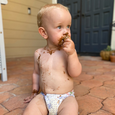 Shirtless baby Bryce eating ice cream