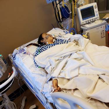 Desiree recuperating, laying on hospital bead