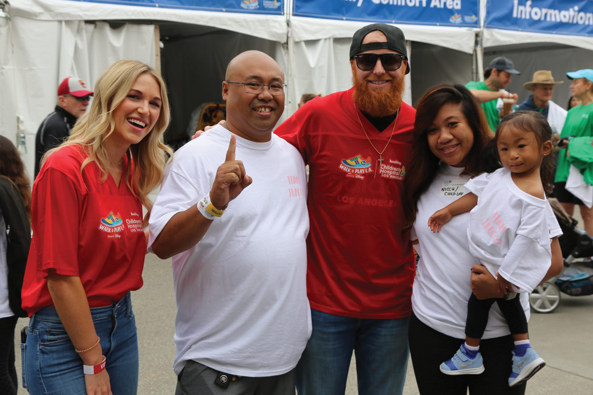 Los Angeles Dodgers third baseman Justin Turner and his wife, Kourtney (both in red), with CHLA Junior Ambassador Julie Rose Osumi-Cabaya and her family