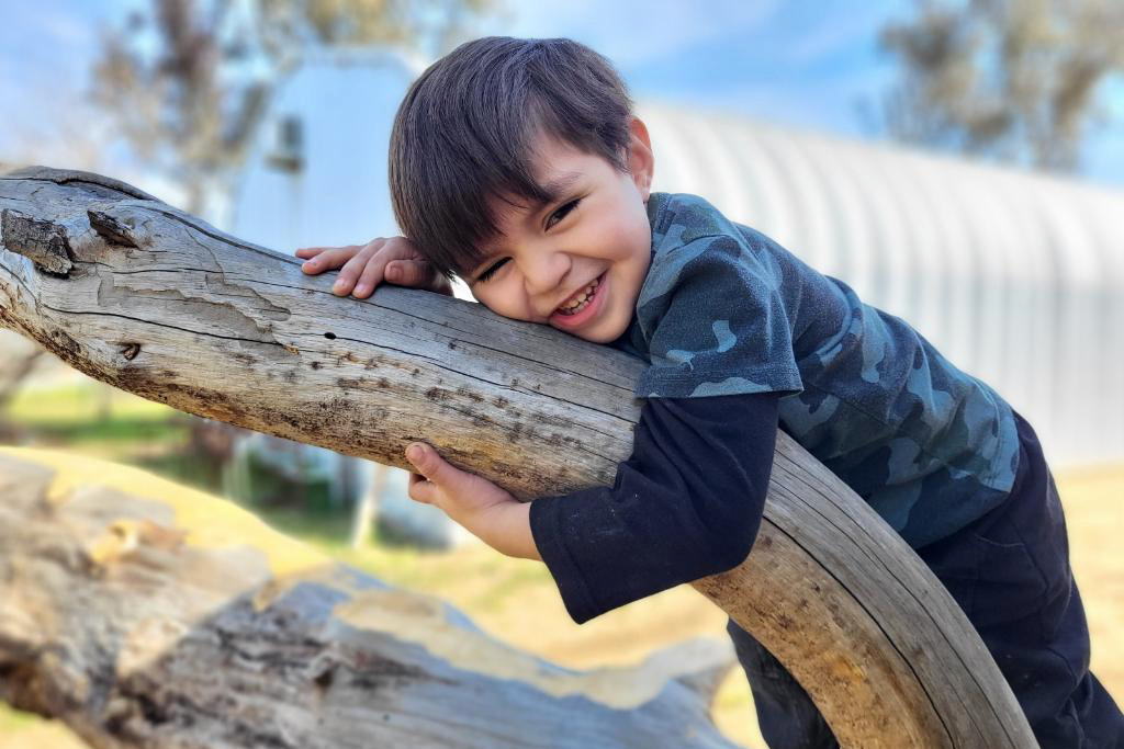 4-year-old Martin hugs tree branch