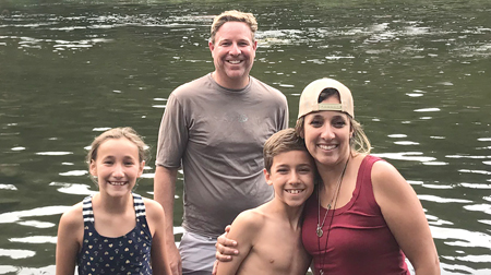 Group photo of patient Gracie with her parents and twin brother in a lake setting
