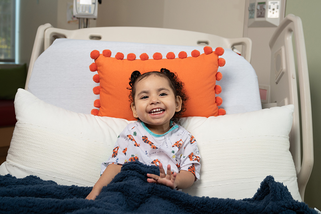 Genesis smiles in her hospital bed
