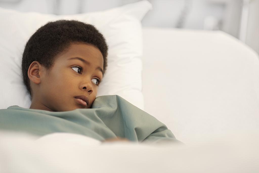 Little boy looks to the side in his hospital bed