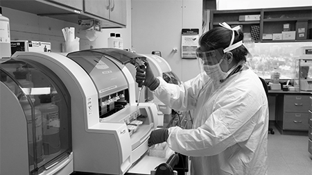 Lab scientist working with a testing machine