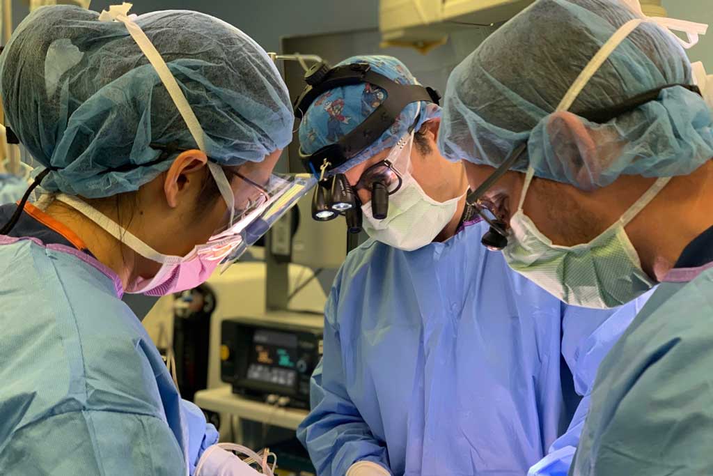 Peter Chiarelli, MD, DPhil and other surgeons at an operating table