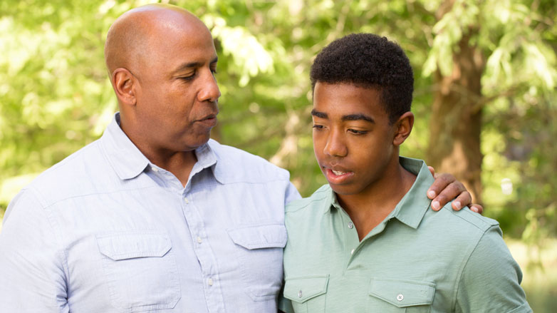 African-American father talking with son